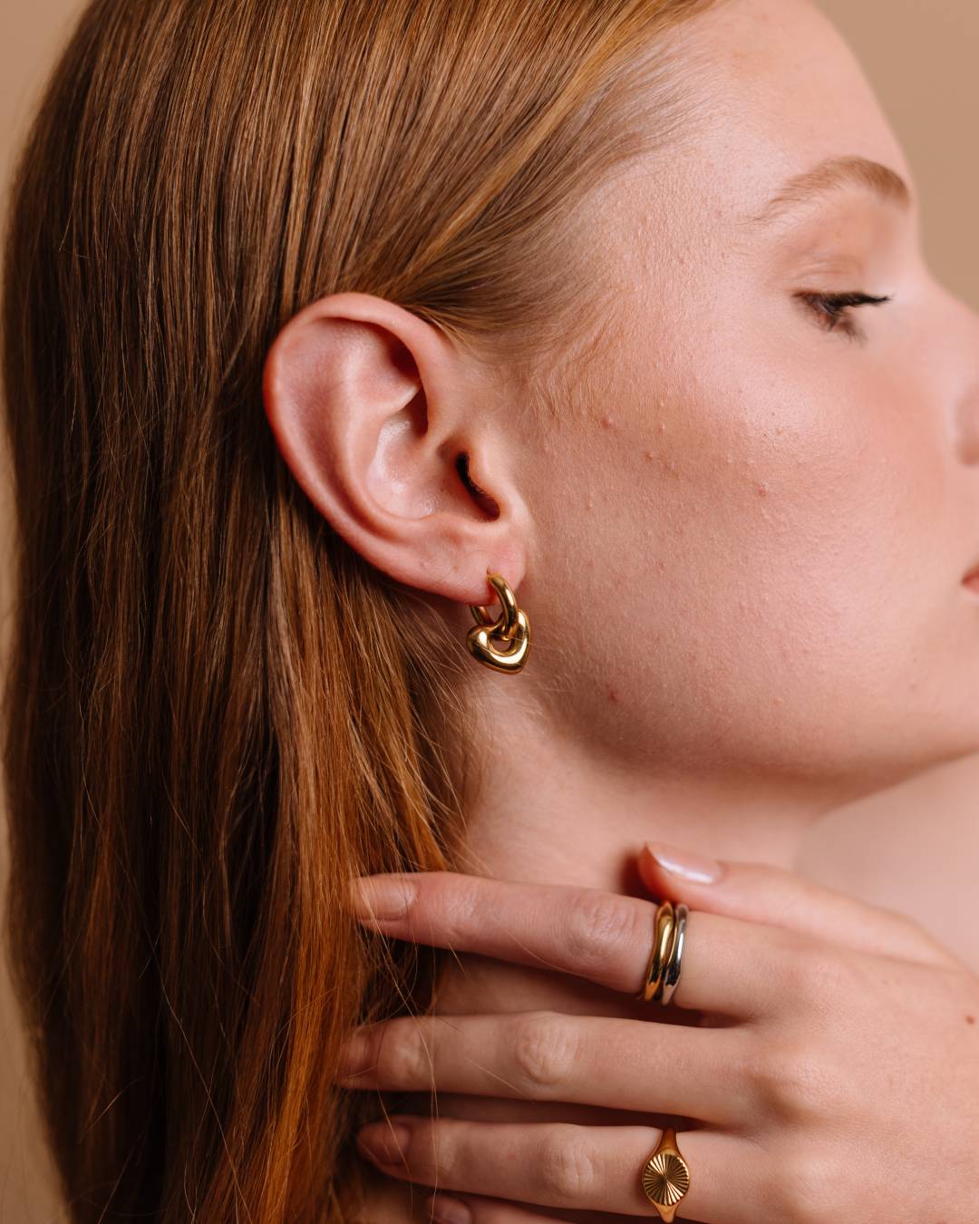 Waterproof gold plated huggie hoop earring with removable heart charm and gold plated rings